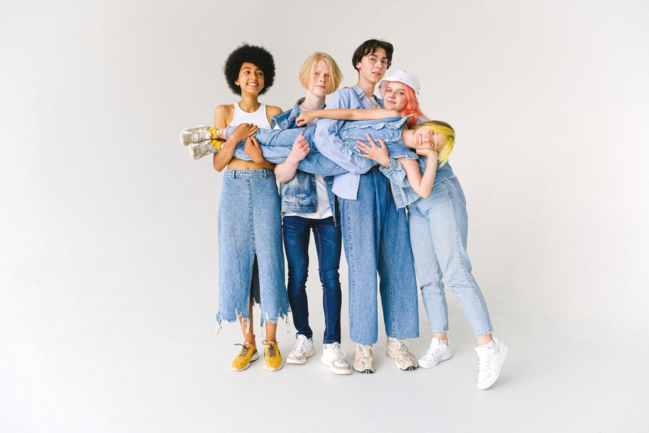 Group of people comparing casual denim outfits in a studio