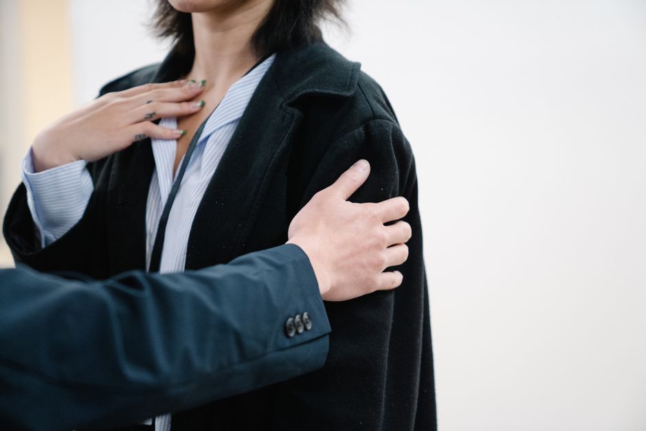 Detailed close-up image showing a person in a black blazer with hands gesturing on chest. Great for business and lifestyle themes.