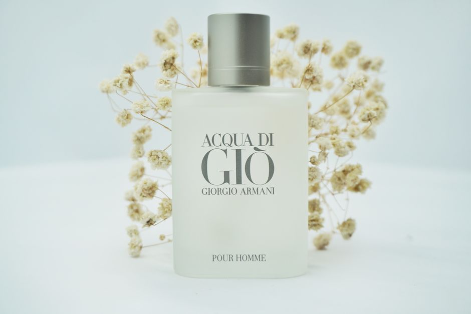 Minimalist product shot of a perfume bottle with delicate floral background.